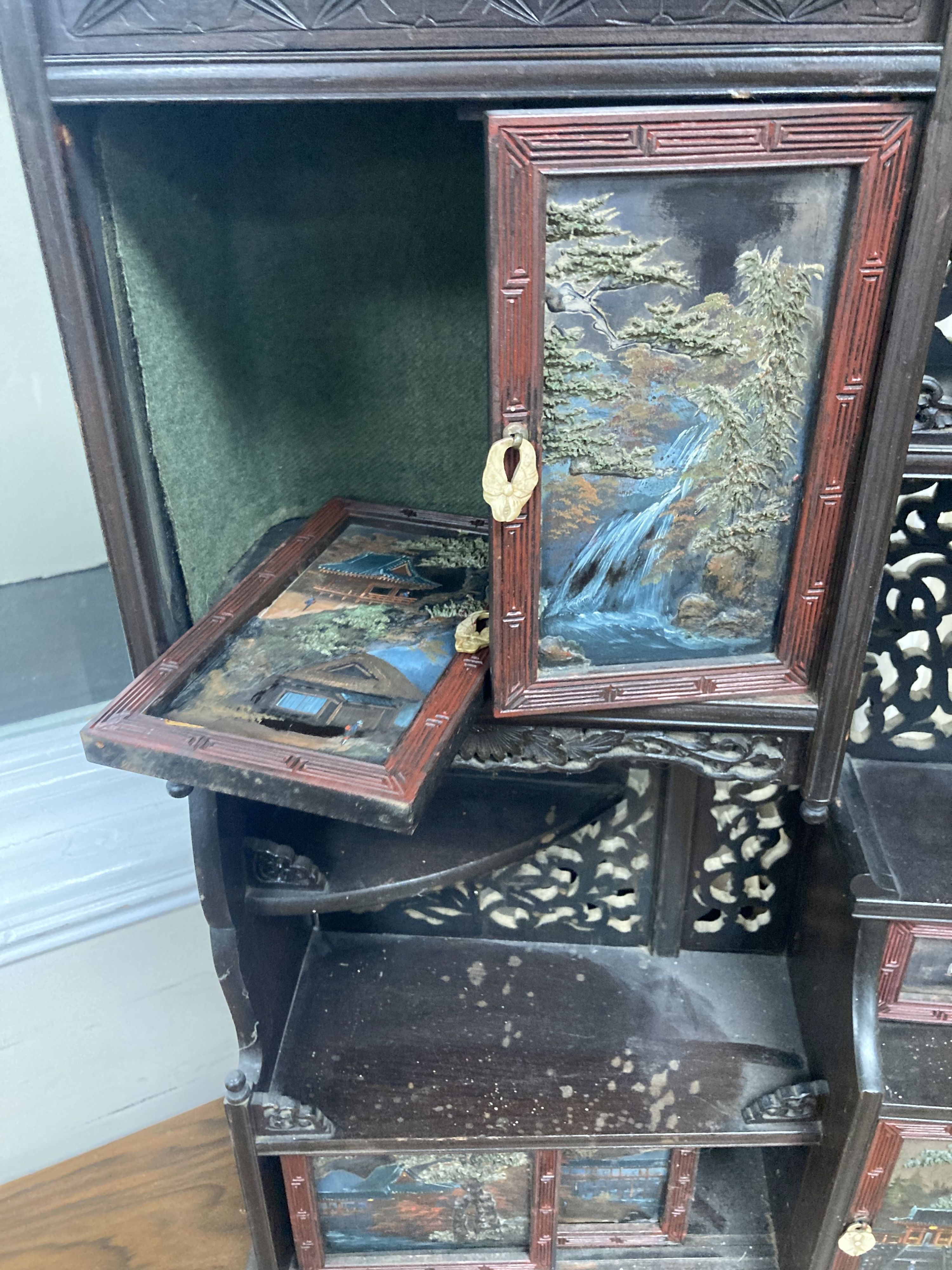 A 20th century Chinese carved cabinet with painted hinged cupboard doors, 79cm height, width 52cm, depth 18cm